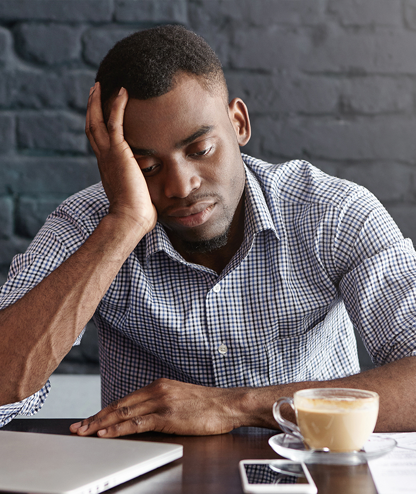 Unhappy man leaning on his desk.