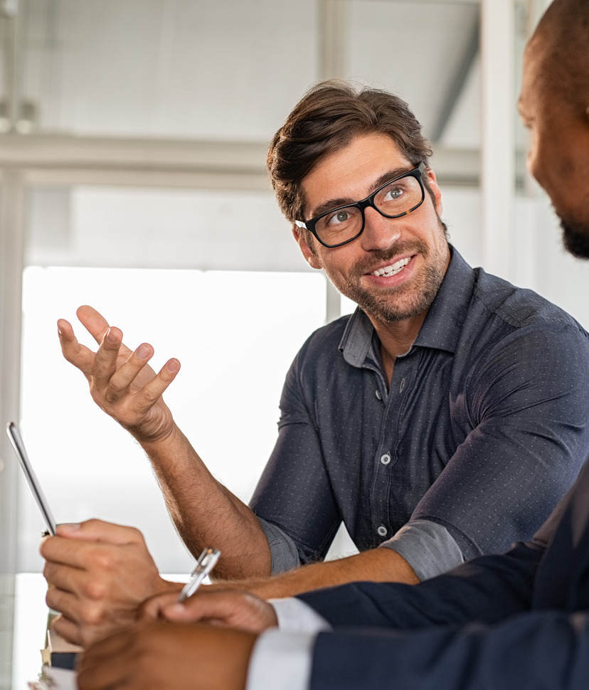 Photo of a handsome businessman at work, talking to a colleague