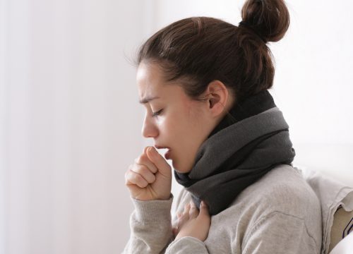 A woman with a cold and a scarf around her neck.