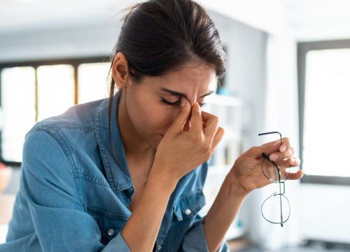 Woman pinching the bridge of her nose.