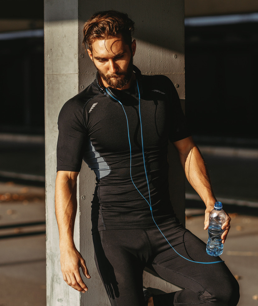 Photo of a man on jog stopping to take a drink of water